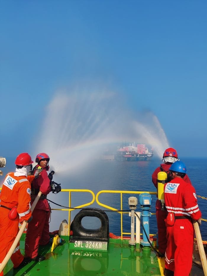 Seafaring emergency team conducts a drill with fire hoses to simulate rescue operations.